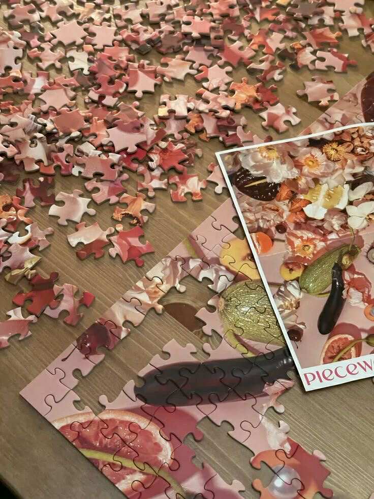 Puzzle pieces spread out on wooden surface